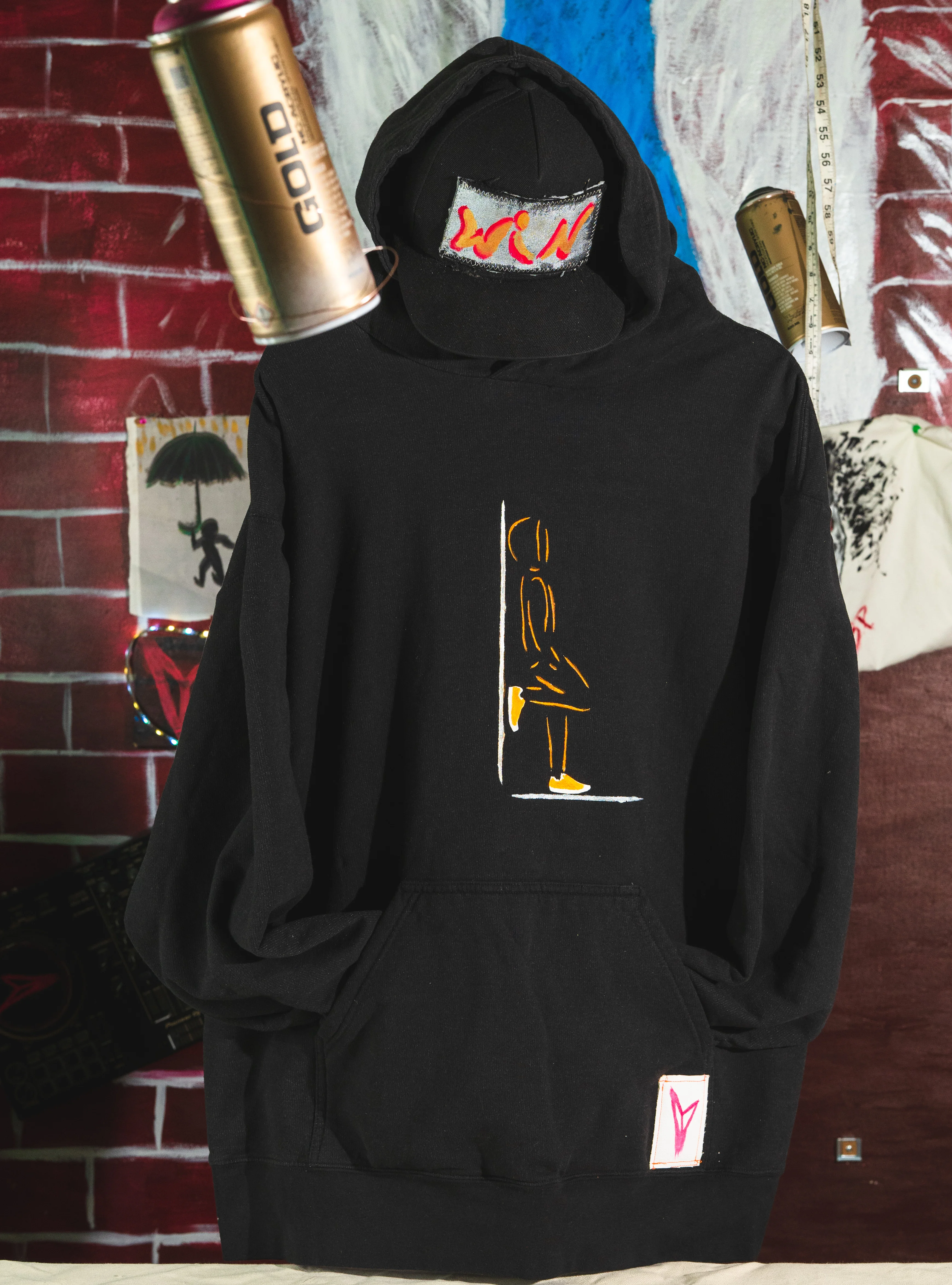 Model wearing custom graphic hoodie in front of a brick wall