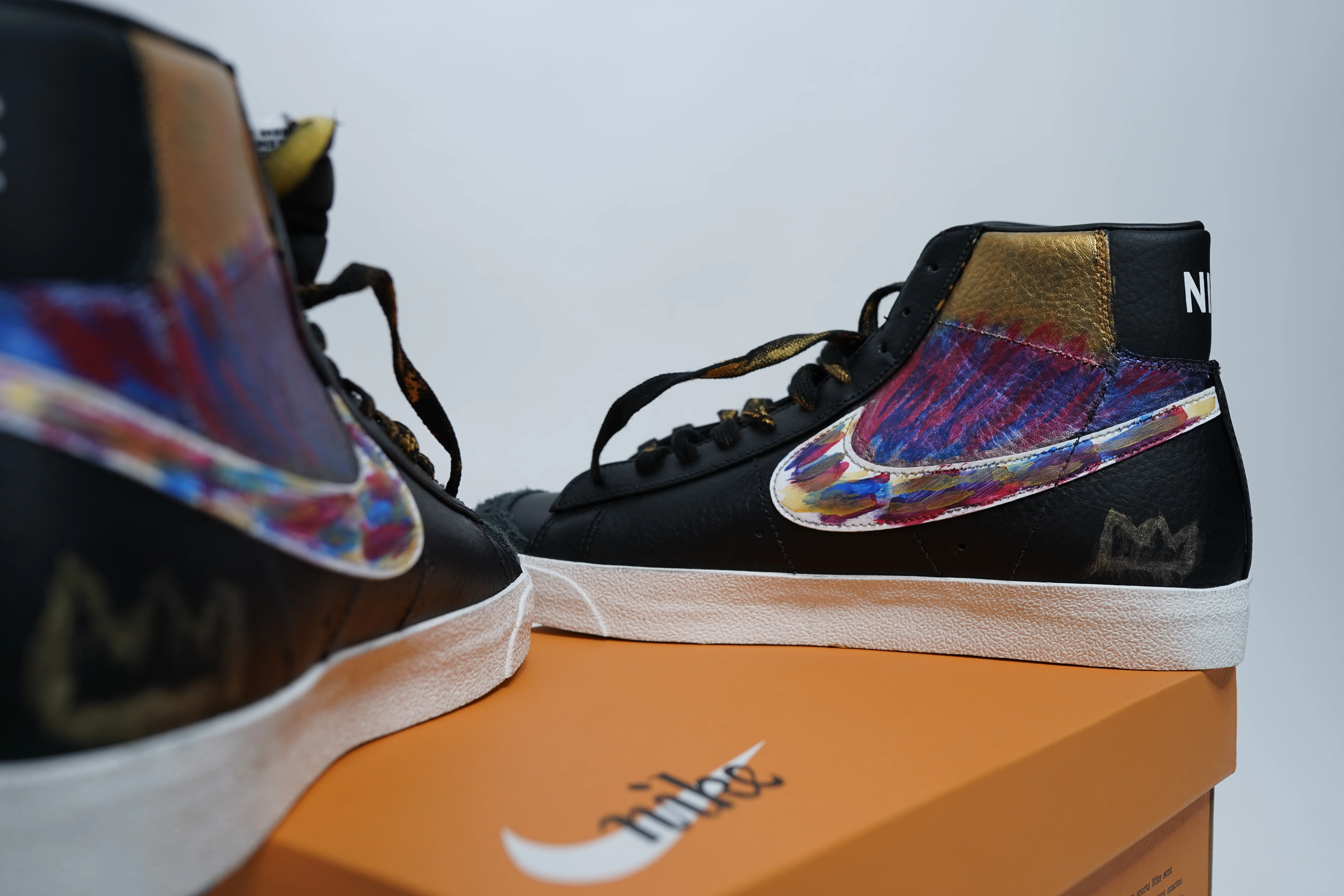 Custom hand-painted Nike Blazer Mid sneakers in black leather with gold and multicolor Swoosh
